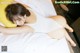 A pregnant woman laying on a bed with a yellow pillow.