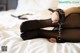 A woman in black stockings and handcuffs laying on a bed.