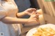 A woman lighting a candle at a table with a plate of food.