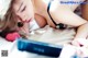 A woman laying on top of a bed next to a book.