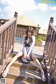 A woman sitting on a wooden deck holding a basketball.