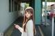 A woman with long brown hair standing in a train station.